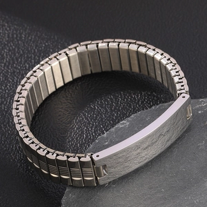 Macro shot of silver stainless steel elastic watch band bracelet with curved ID plate
