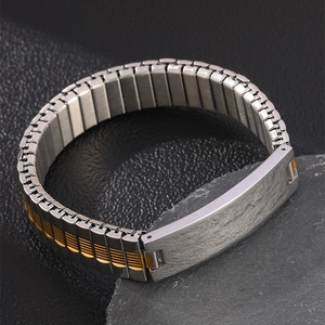 Macro detail of men's two-tone elastic steel bracelet with texture engraving plate