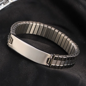 Macro detail of polished stainless steel ID bracelet with expansion band on black silk