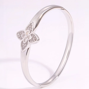 Close-up of silver clover bangle with micro-paved rhinestones on high-polish steel