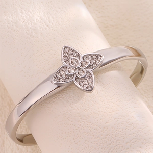 Elegant stainless steel silver bangle bracelet featuring a paved crystal clover motif for women