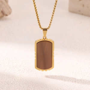 Collana da uomo con piastrina in acciaio al titanio dorato e inserto in legno su sabbia