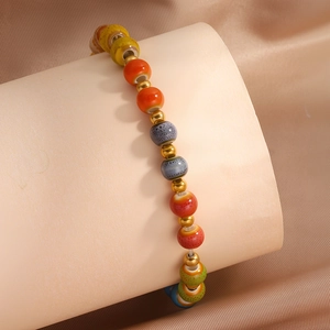Detailansicht bunter glasierter Keramikperlen und goldener Metallzwischenstücke am Armband