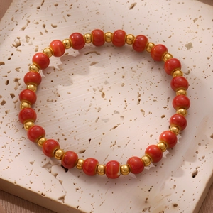 Elegantes chinesisches Keramik-Perlenarmband mit roten und goldenen Perlen auf Stein