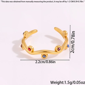 Detailed view of wave-shaped titanium steel gold ring with multicolored crystals