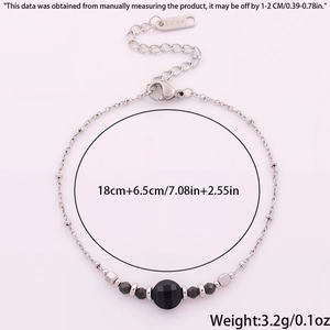 Détail du bracelet en acier inoxydable argenté avec perle noire facettée et fermoir mousqueton