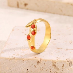 Détails macro d'une bague serpent plaquée or 18 carats avec quatre cristaux rouges