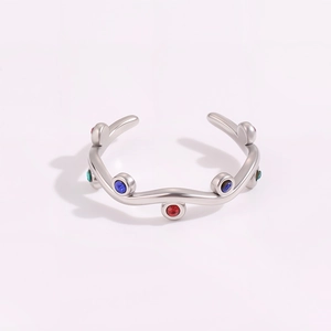 Detailed macro view of silver wavy stainless steel ring with colorful inlaid stones