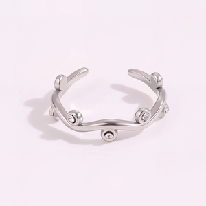 Close-up of wavy silver titanium ring featuring sparkling zircon inlay in a minimal style