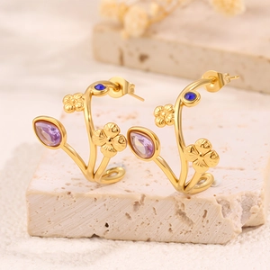 Gros plan de boucles d'oreilles fleurs en C avec pierres violettes et cristaux bleus