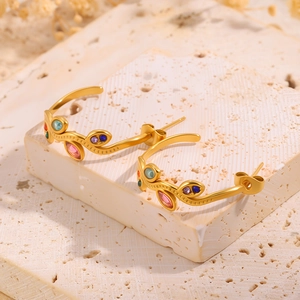 Gros plan sur les boucles d'oreilles feuilles en C, acier plaqué or 18k et cristaux colorés