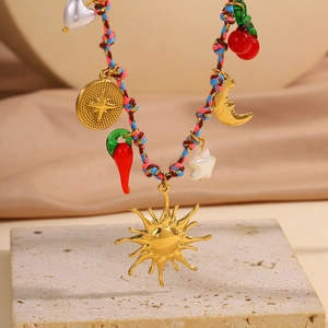 Détail du collier en corde tressée colorée avec charms soleil, lune et cerise sur pierre