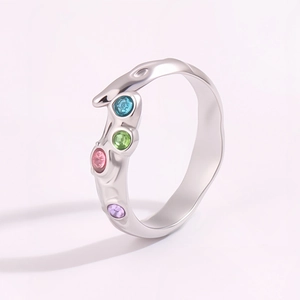 Détail de la bague irrégulière en métal liquide argenté sertie de quatre pierres colorées