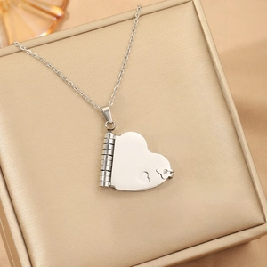 Macro di ciondolo a cuore in argento con motivi floreali su una scatola di gioielli oro
