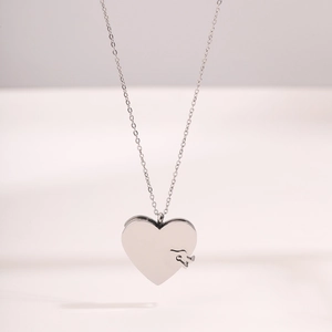 Détail d'un pendentif en forme de cœur avec un élément de puzzle sur une chaîne argentée