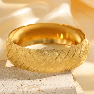 Macro detail of Chinese style gold titanium bangle with frosted finish and diamond pattern