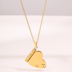 Dettaglio macro della collana con medaglione a cuore dorato e finitura lucida a specchio