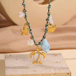 Détail du collier tissé bohème avec pendentifs dorés en forme de tortue et d'étoile de mer