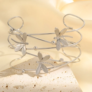 Detailaufnahme einer silbernen Libellen-Manschette mit mehreren Strängen auf Stein