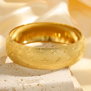 Gold plated matte stainless steel wide bangle with star pattern on stone and silk