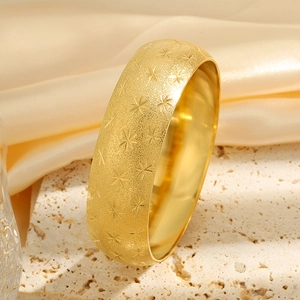 Gold wide titanium steel bangle with frosted sand finish and engraved star patterns