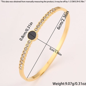 Detailed view of oval gold titanium steel bangle with black enamel and embedded rhinestones