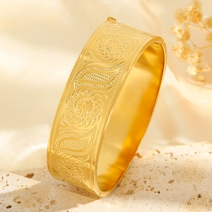 Gold-plated sunflower embossed stainless steel hinge bangle on white silk background