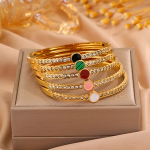 Detail view of five gold-plated titanium steel bangles with colorful crystal inlays