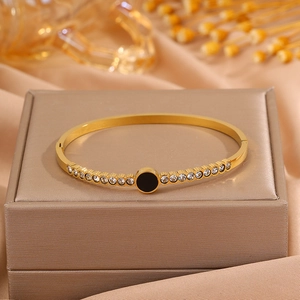 Detail shot of a gold-plated titanium steel bangle with a black inlay and sparkling zircons