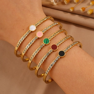 Set of five gold titanium steel bangles with sparkling crystals and colored stone centers