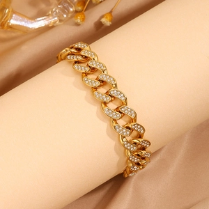 Primer plano detallado de la pulsera cubana dorada con diamantes pavé brillantes en soporte