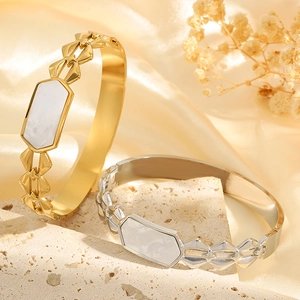 Elegantes brazaletes de oro y plata con incrustaciones de concha sobre seda de lujo