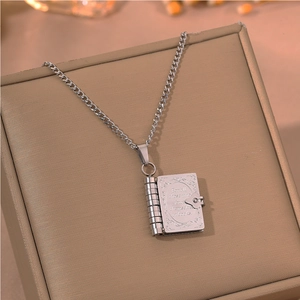 Close-up of vintage book locket necklace with inspirational text on jewelry box
