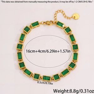 Detailed close-up of golden stainless steel bracelet with rectangular green emerald gemstones