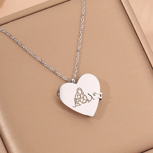 Dettaglio del ciondolo a cuore in argento con incisione su una scatola per gioielli di lusso