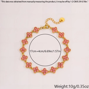 Detail of gold four-leaf clover bracelet featuring sparkling pink zircon floral charms