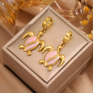 Détail de boucles d'oreilles tortue plaquées or avec émail rose et fermoirs de type huggie