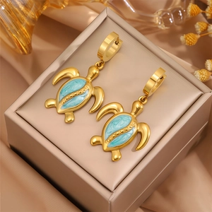 Détail de la boucle d'oreille tortue dorée avec émail marbré bleu clair raffiné