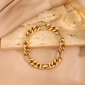 Primer plano de pulsera de eslabones cubanos dorados con detalles de diamantes finos