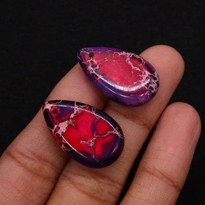 Detailed macro view of two purple teardrop semi-precious stone pendants for DIY jewelry