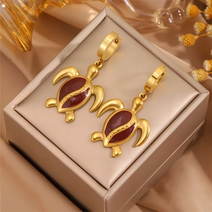 Boucles d'oreilles créoles tortue dorées avec émail rouge-brun sur cuir beige élégant