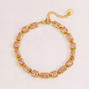 Detailed macro view of gold stainless steel bracelet with pink zircon stones and lobster clasp