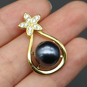Close-up of gold-plated waterdrop pearl pendant with crystal floral design details