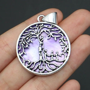 Detailed view of silver tree of life pendant with purple mother of pearl inlay and family silhouette