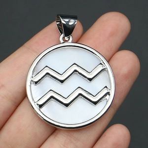 Detail of Aquarius shell pendant with silver frame held by hand for scale and texture