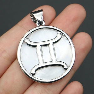 Macro shot of silver circular Gemini pendant with white mother-of-pearl inlay