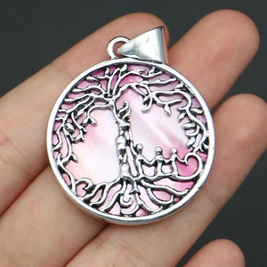 Macro shot of a tree of life shell pendant with family silhouette held in a palm