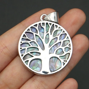 Close-up of a silver tree of life pendant with colorful abalone shell inlays