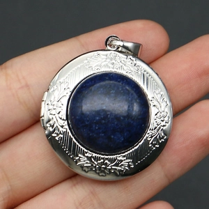 Detail of vintage locket with blue gemstone and intricate floral engraved patterns