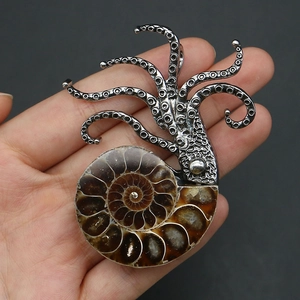Macro shot of ammonite fossil pendant with silver octopus detail held in hand